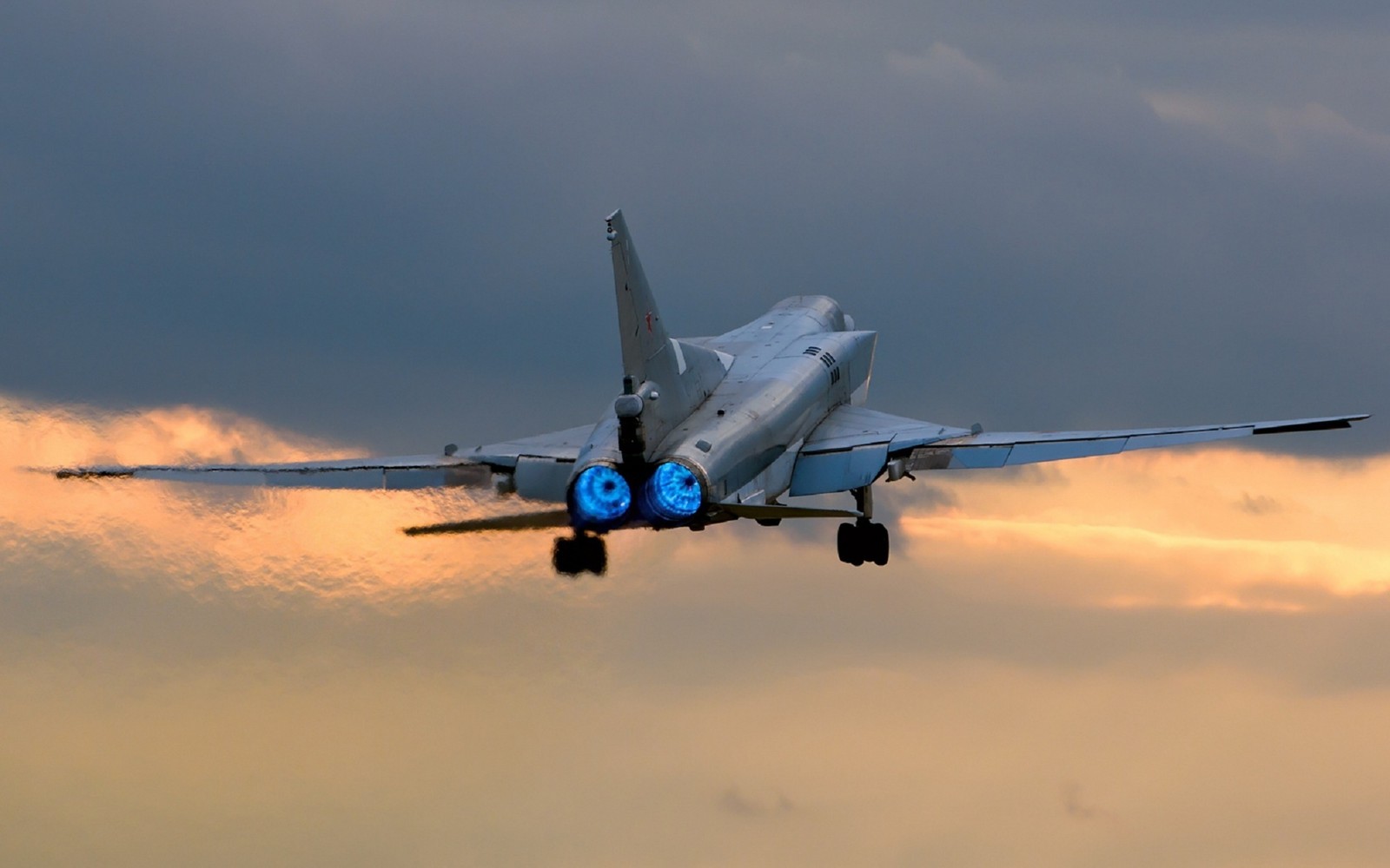 Há um jato que está voando no céu com uma luz azul nele (tupolev tu 22m, aeronave, tupolev, aviação, engenharia aeroespacial)