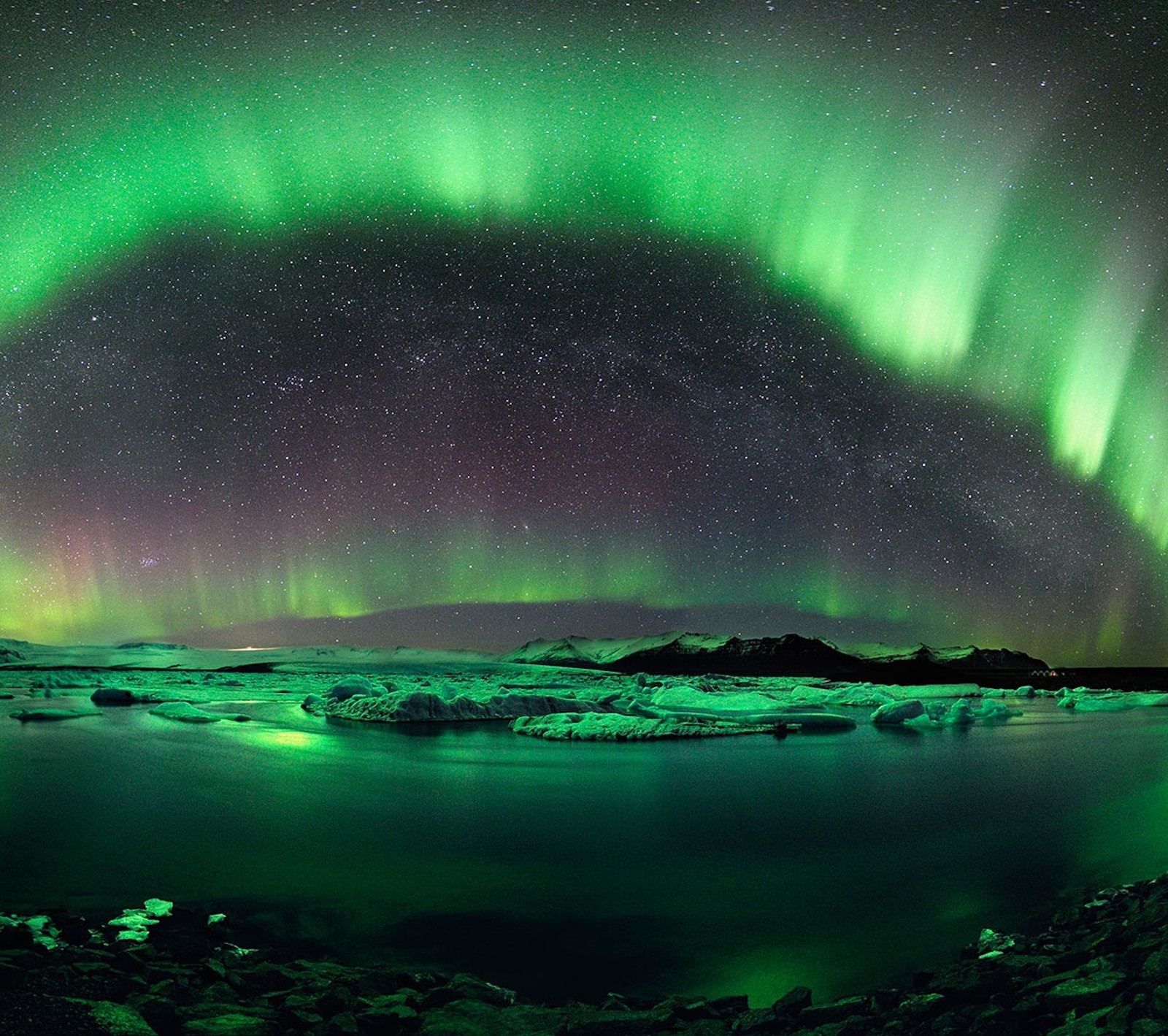 Uma aurora boreal verde sobre um lago e icebergs à noite (luz, céu)