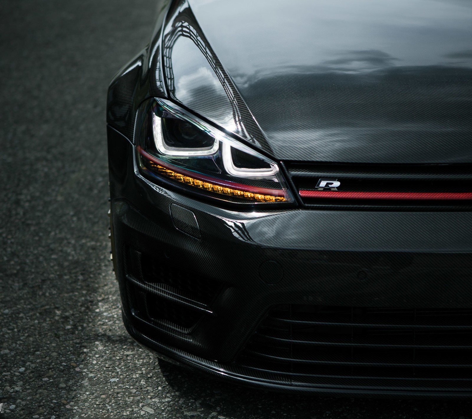 A close up of a black car with a red tail light (car, carbon fiber, golf r, mk7, tuning)