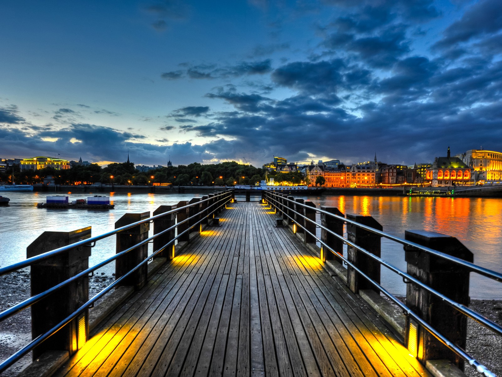 Quai en bois avec des lumières au crépuscule surplombant une ville (hd, nature, paradis)