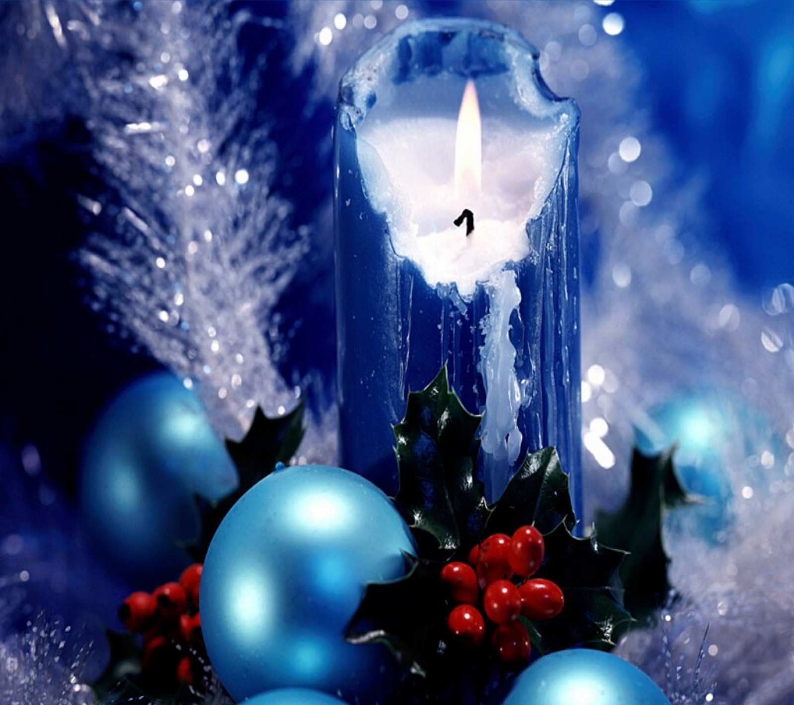 Uma vela com um porta-vela e enfeites em cima dela (azul, vela, natal, feriado, mistletoe)