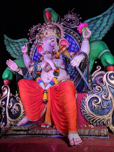 Ídolo vibrante de Ganesh adornado con loros y ofrendas florales