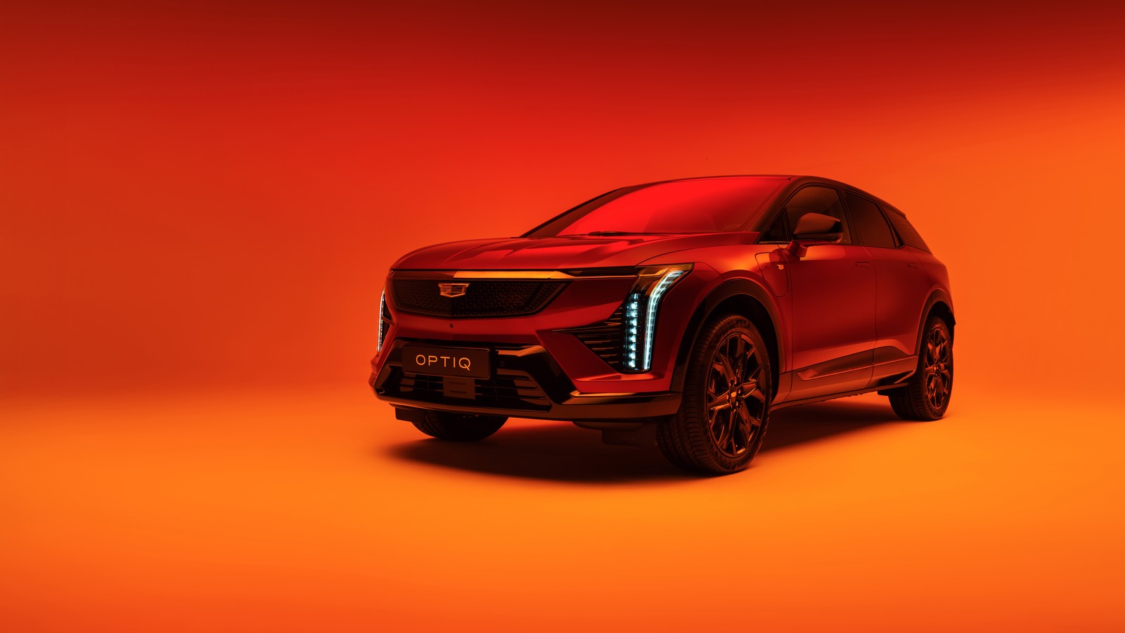 Um carro vermelho com um fundo laranja brilhante (cadillac optiq, 2025, suv elétrico, fundo laranja, 5k)