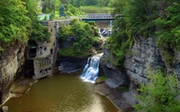 Scenic Waterfall Cascading into a Tranquil River Surrounded by Lush Greenery