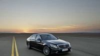 Sedán Mercedes-Benz en una carretera abierta al atardecer