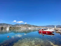 Aguas serenas de las tierras altas con reflejos y embarcaciones