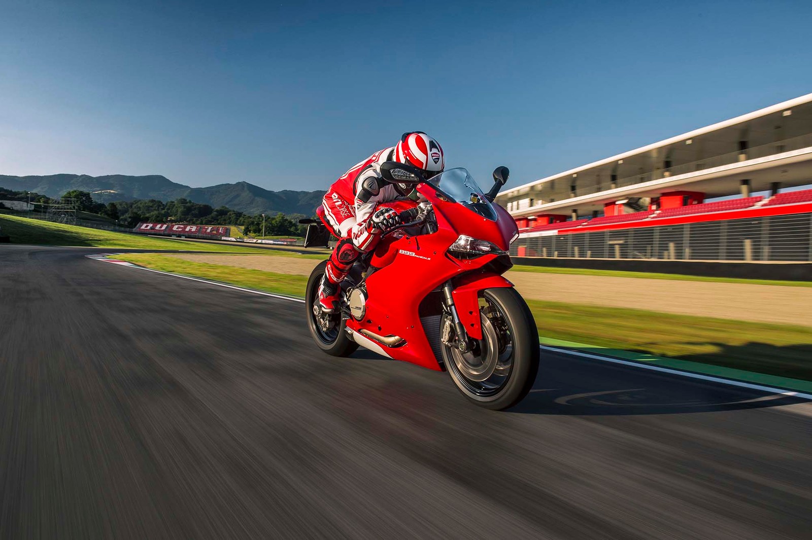 Ein arabischer motorradfahrer auf einem roten motorrad auf einer rennstrecke (ducati 899, ducati, motorad, ducati 1199, sportmotorrad)