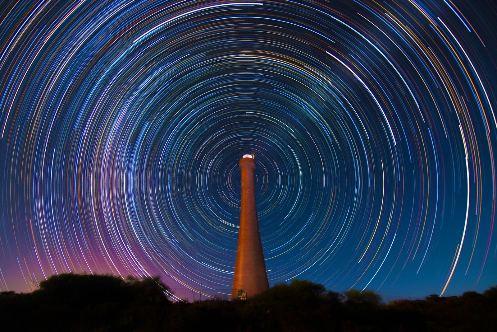 Uma vista de um farol com um rastro de estrelas no céu (guilderton lighthouse, austrália, rastro de estrelas, tempo noturno, circular)