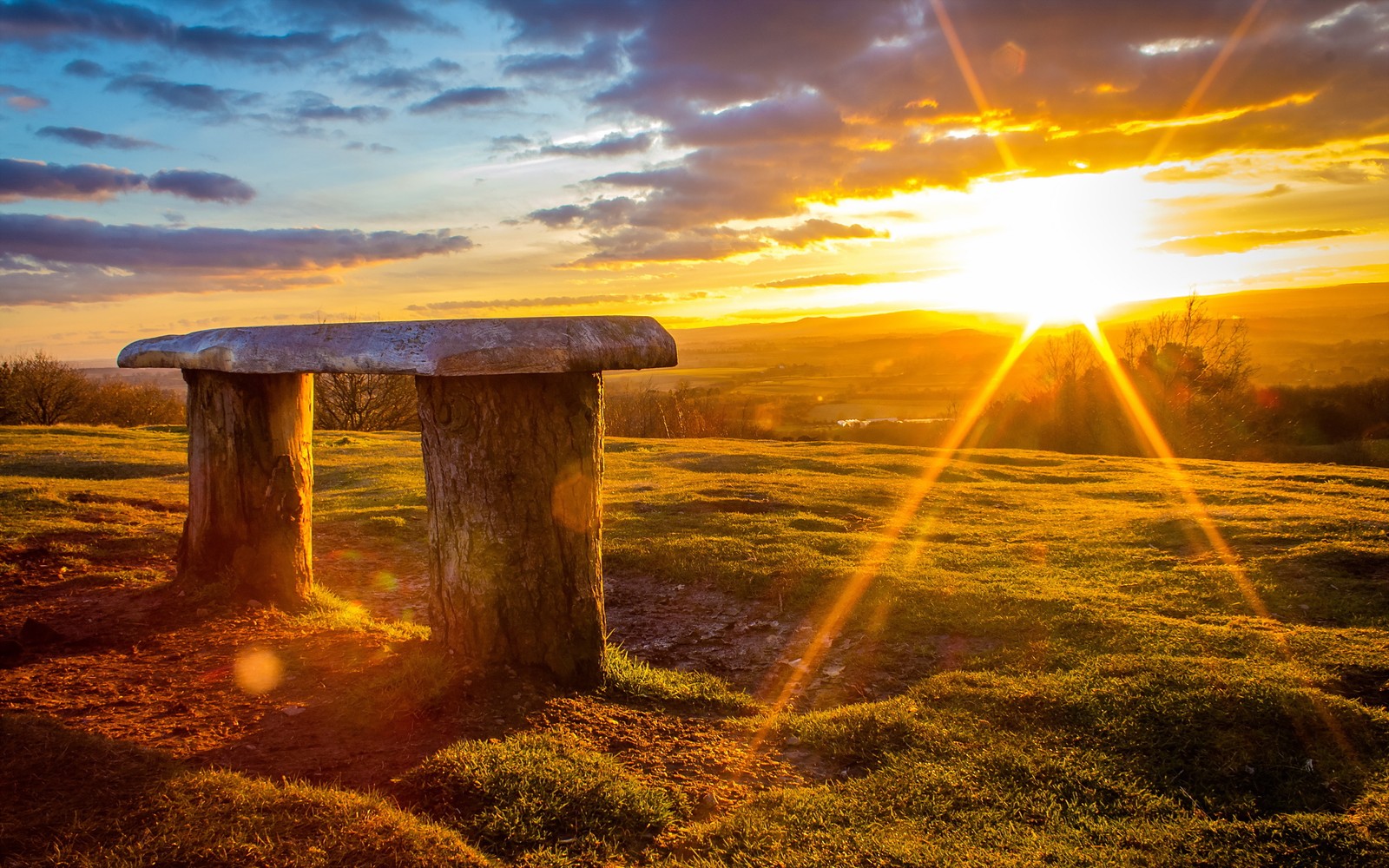 Nahaufnahme einer bank auf einem feld mit sonnenuntergang im hintergrund (sonnenlicht, sonnenaufgang, morgen, wolke, horizont)