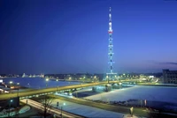 Illuminated Skyscraper Tower Overlooking a Cityscape at Dusk