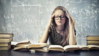 Estudante lutando com os estudos em meio a livros abertos na sala de aula