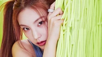 Yeji de ITZY dans une prise de concept vibrante, mettant en valeur son regard percutant sur un fond vert vif.