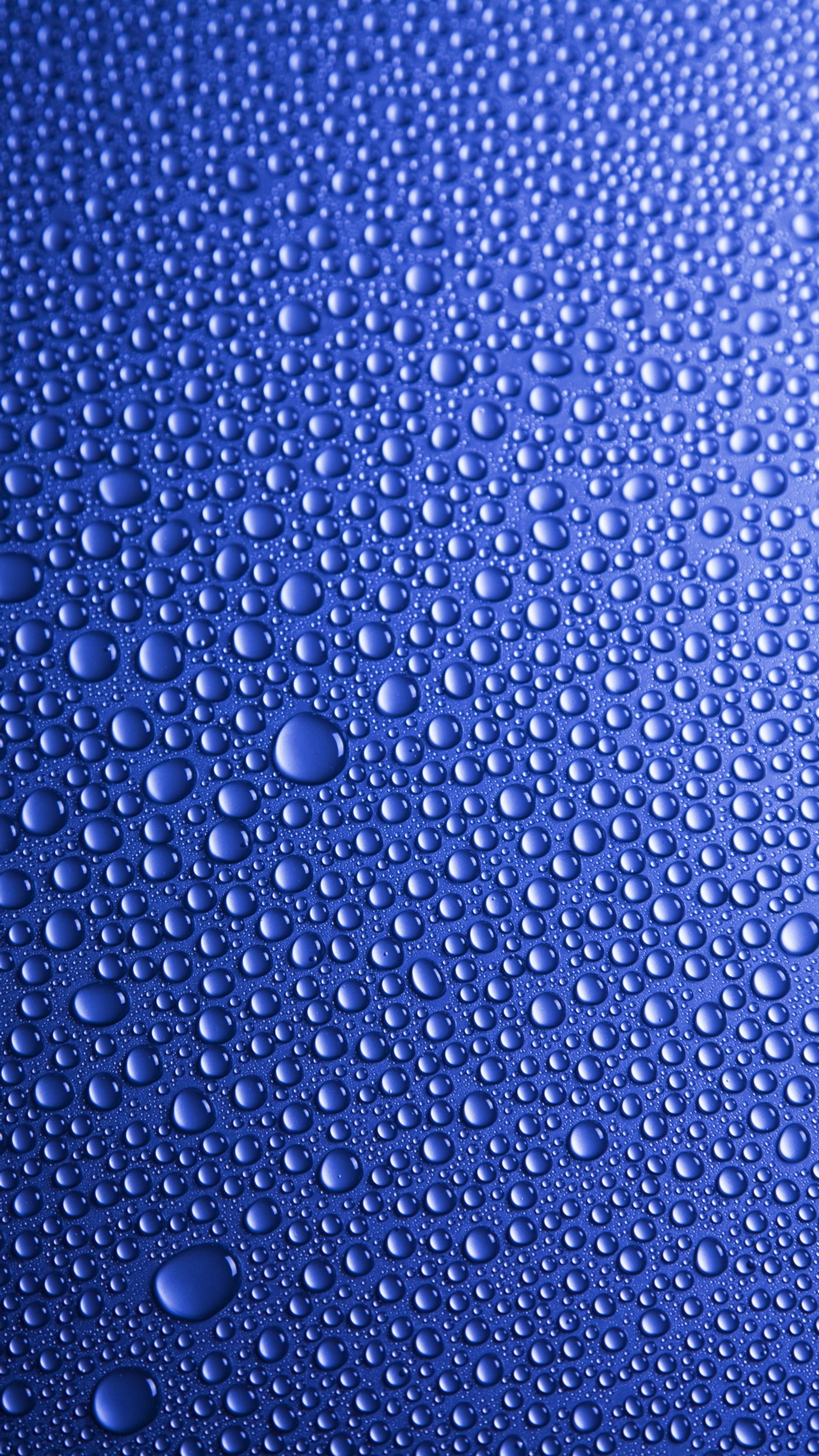 Un primer plano de gotas de agua en una superficie azul (abstracto, fondo, azul, burbujas, gotas)