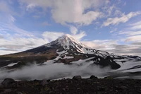 Majestueux stratovolcan éteint au milieu d'une nature couverte de nuages