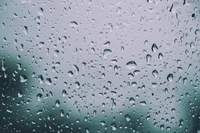 Gotas de lluvia en una ventana de tono teal