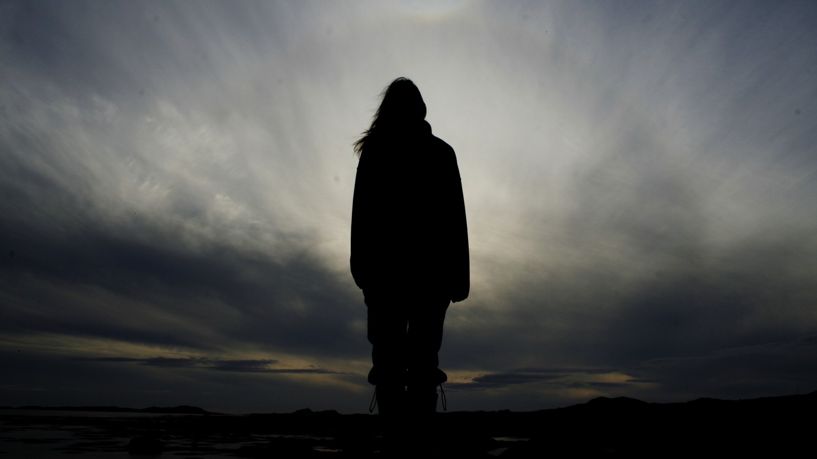 Silhouette d'une personne debout sur une plage au coucher du soleil (nuage, debout, youtube, atmosphère terrestre, horizon)