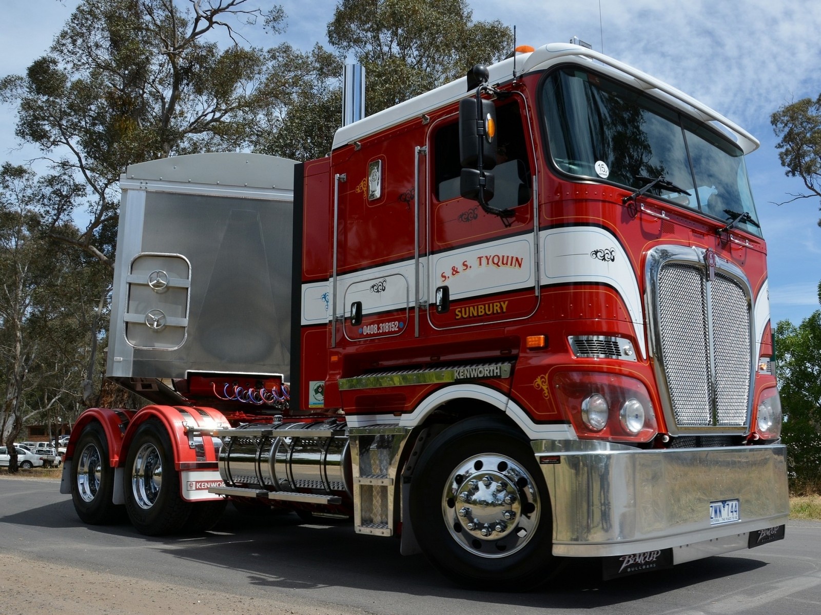 Araf truck with a trailer on the road in front of trees (trailer truck, bumper, truck, transport, automotive exterior)