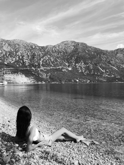 Tomando sol à beira de um lago sereno com fundo montanhoso