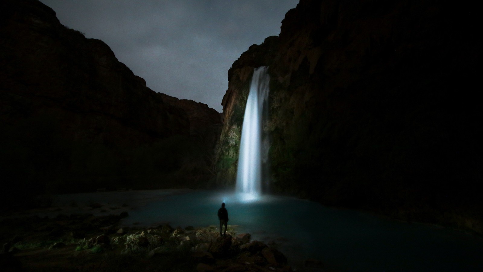 Eine person steht nachts vor einem wasserfall (wasserfall, gewässer, natur, wasser, wasserressourcen)