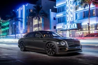 Elegante Bentley Flying Spur Hybrid bajo luces de neón en una vibrante escena nocturna