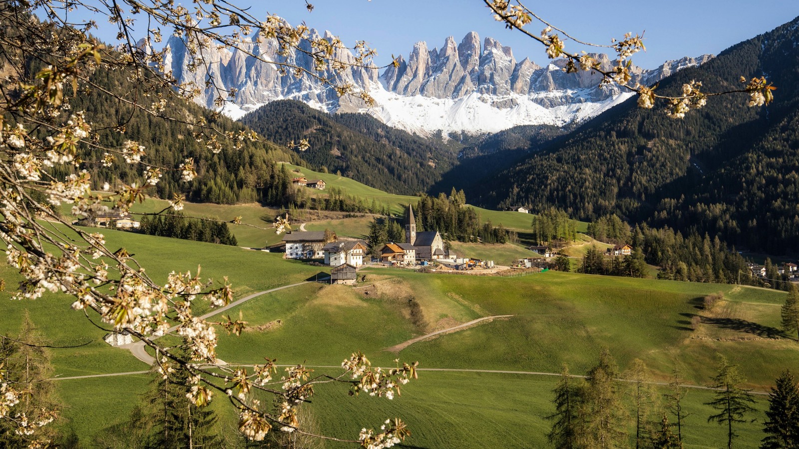 Eine ansicht eines kleinen dorfes in den bergen mit einem schneebedeckten berg im hintergrund (dolomiten, dolomites, berg, pflanze, tageszeit)