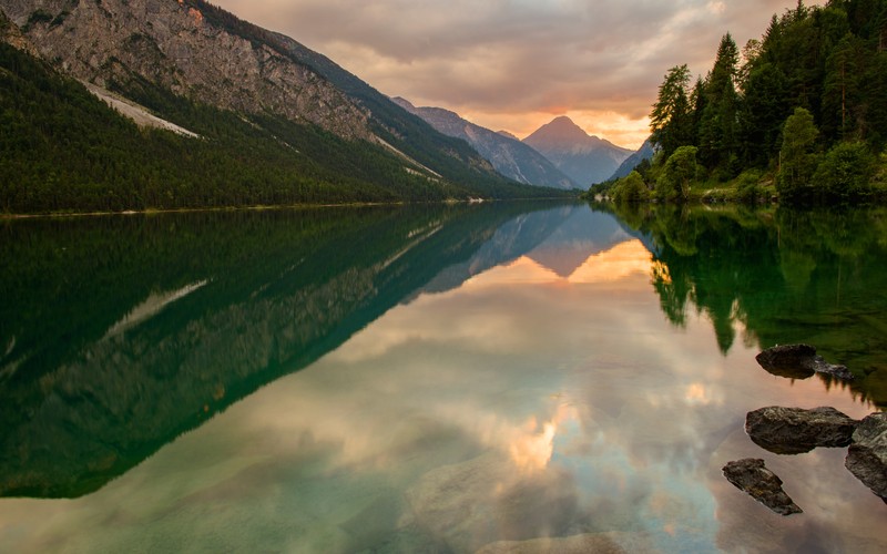 Горы отражаются в воде озера на закате (озеро плэнзее, lake plansee, австрия, thaneller mountain, пейзаж)