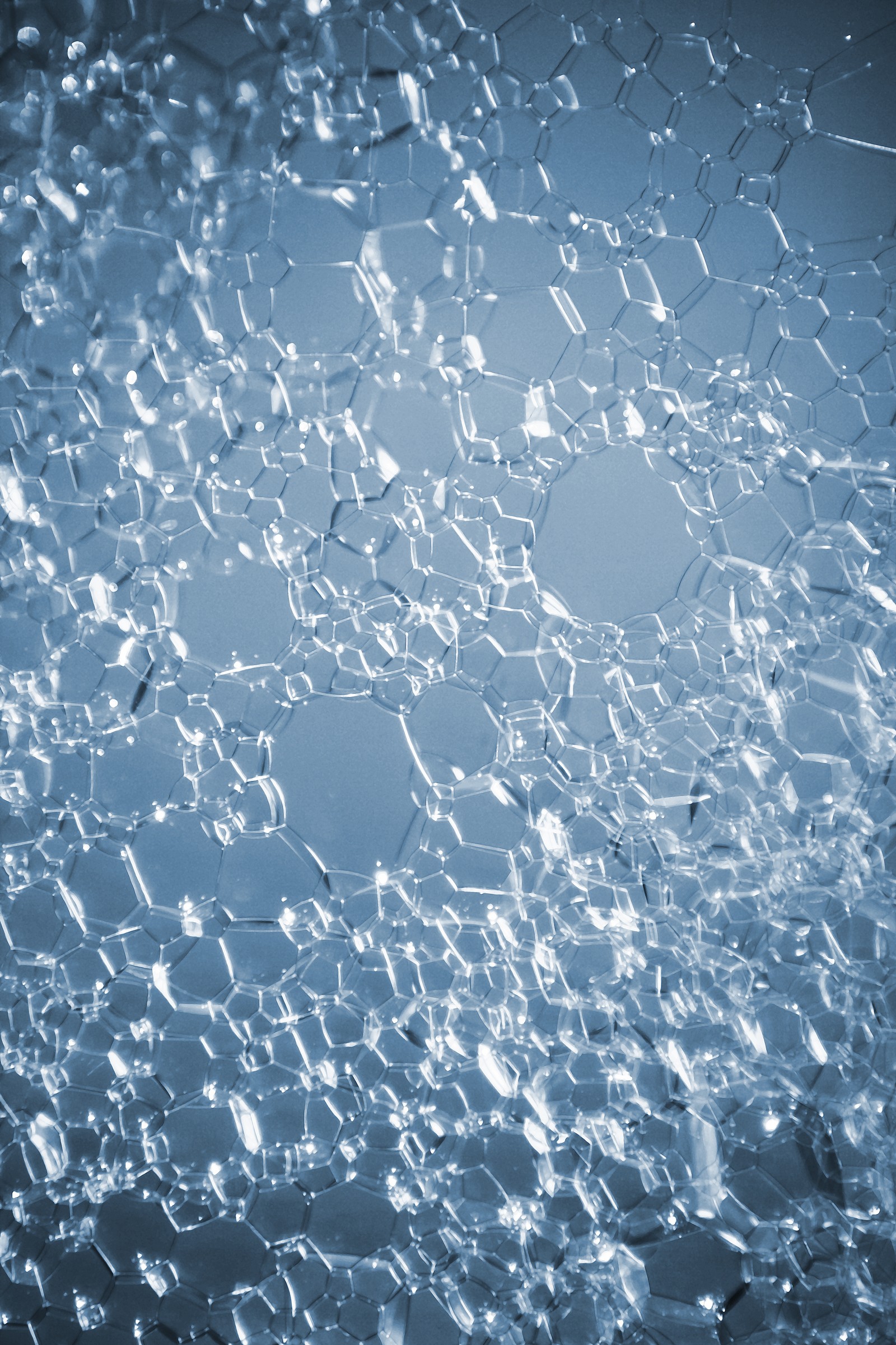 A close up of a window with a lot of water on it (blue, bubbles, foam)