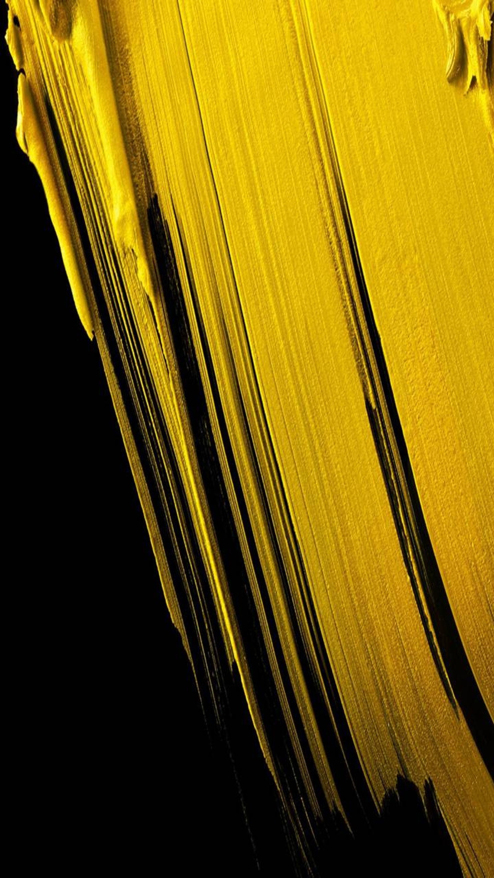 Yellow paint is being swirled on a black surface (essential, eyad, phone, yellow)