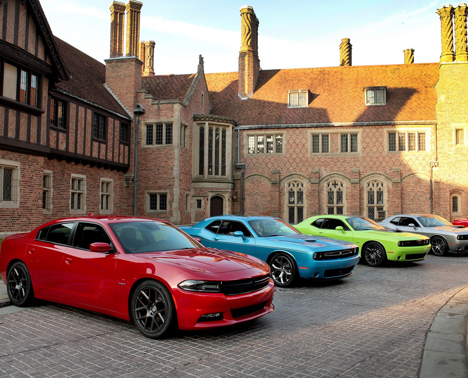 Uma imagem borrada de um grupo de carros estacionados em frente a um prédio (aniversário, carro, desafiante, dodge, hellcat)