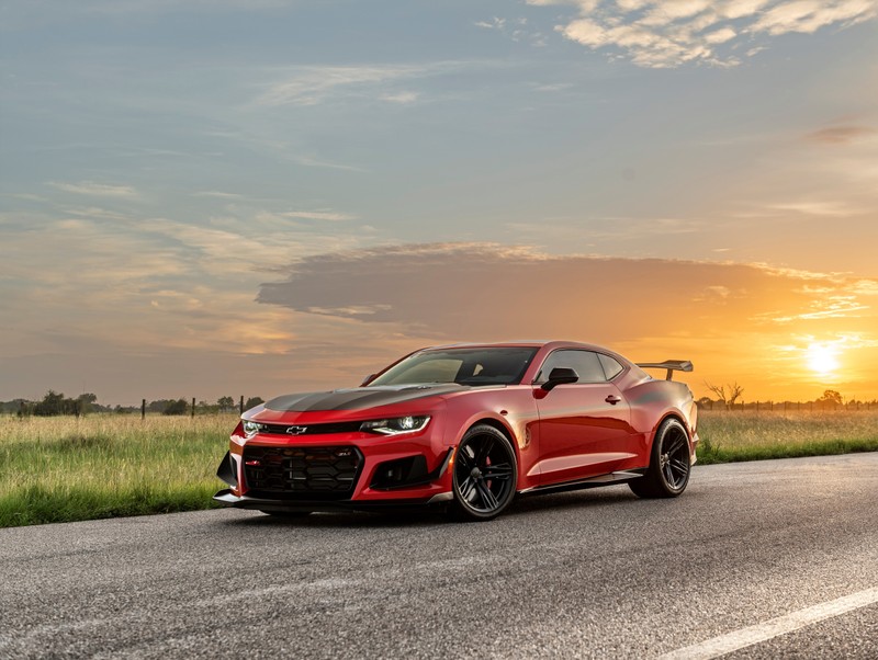 Красный chevrolet camaro едет по загородной дороге на закате (hennessey chevrolet camaro zl1 the exorcist, юбилейное издание, 2021, 5k, машины)