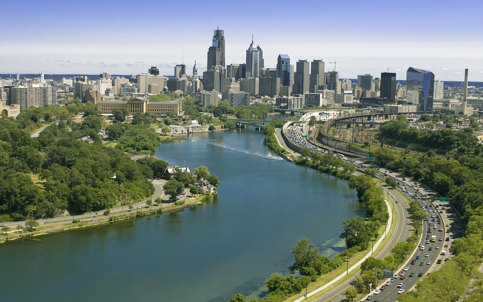 Una vista panorámica de una ciudad con un río y un puente (paisaje urbano, ciudad, panorama, área urbana, día)