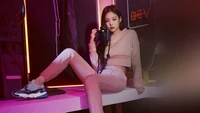 Jennie Kim en un entorno urbano elegante, posando con una cámara en ropa deportiva.