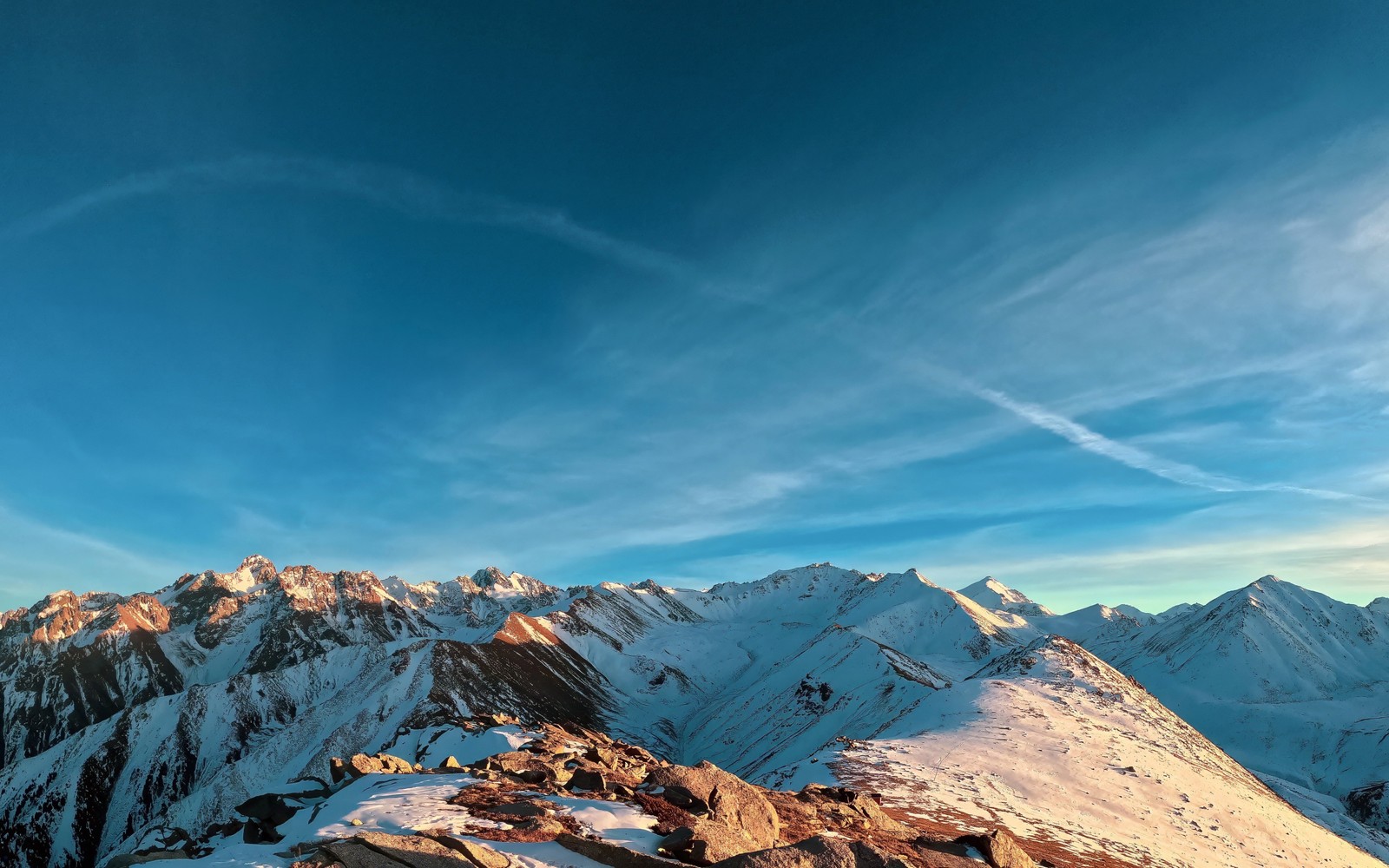 A view of a mountain range with a few snow covered mountains (snowy mountains, scenic, blue sky, outdoor, sunny day)