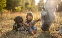 A joyful child playing a ukulele beside a dog and a grazing horse in a sunlit pasture.