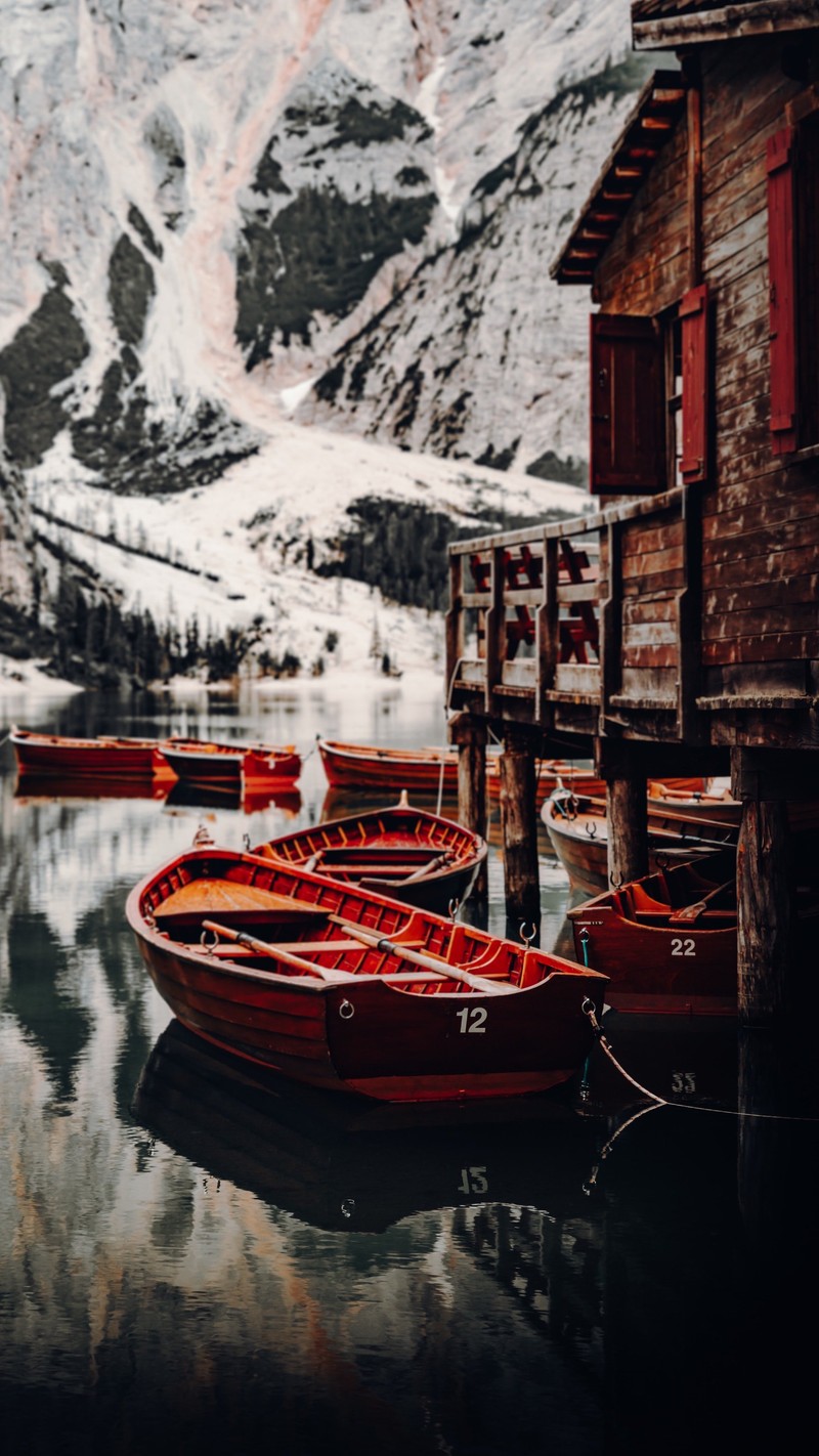 Barcos estão atracados em um lago com uma montanha ao fundo (reflexo, natureza, montanha, temporada, água)