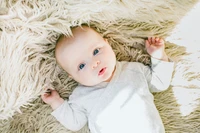 Bébé adorable avec des yeux bleus sur une couverture douce et texturée