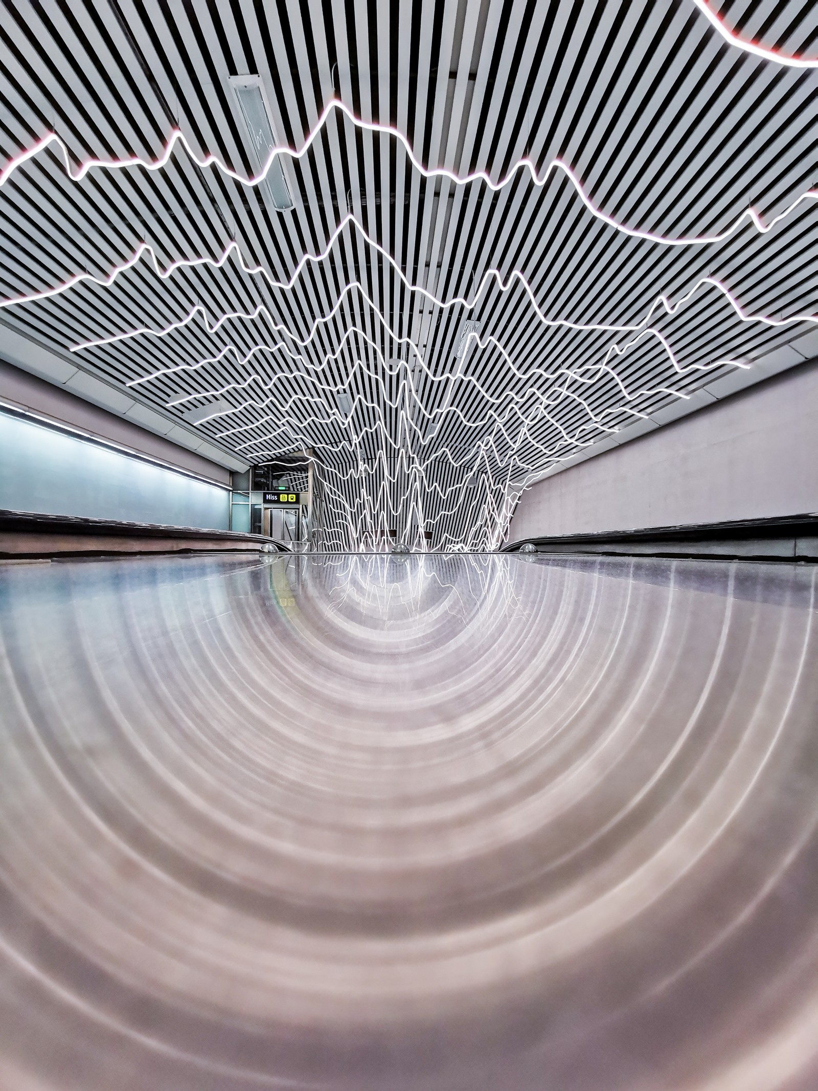 Une photo floue d'une gare avec un train qui passe (architecture, plafond, ligne, eau, infrastructure)