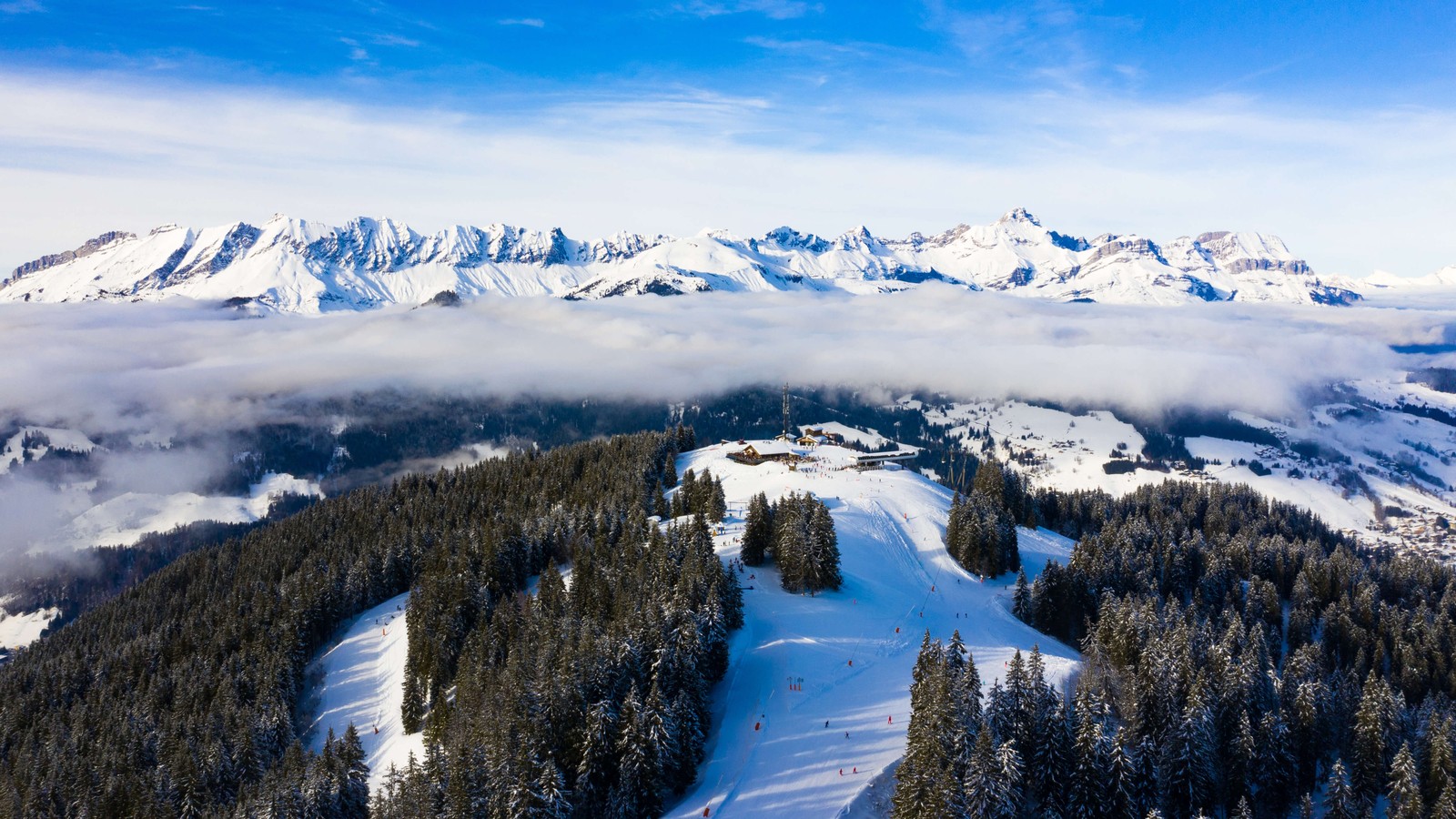 Uma vista de uma pista de esqui com algumas árvores e montanhas ao fundo (montanhas dos alpes, inverno, dia, paisagem, panorama)