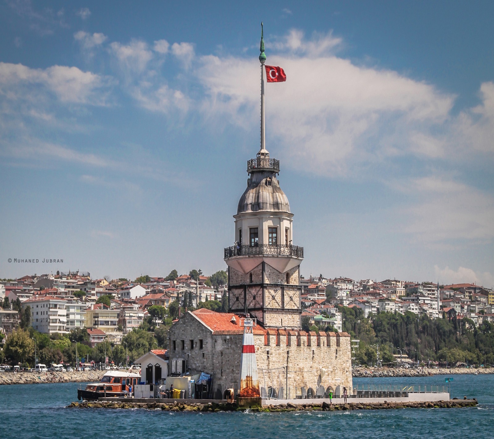 Vista de um edifício com uma bandeira no topo no meio da água (istambul, kizkules)