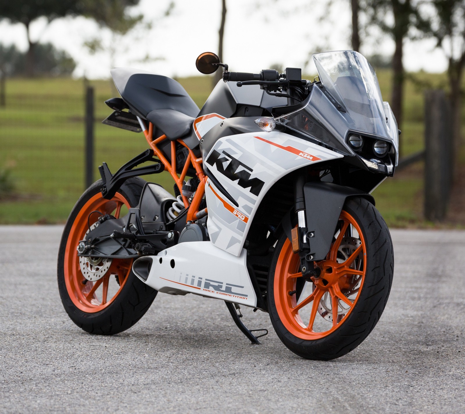 There is a motorcycle parked on the street in the parking lot (austria, black, ktm, motorbike, orange)