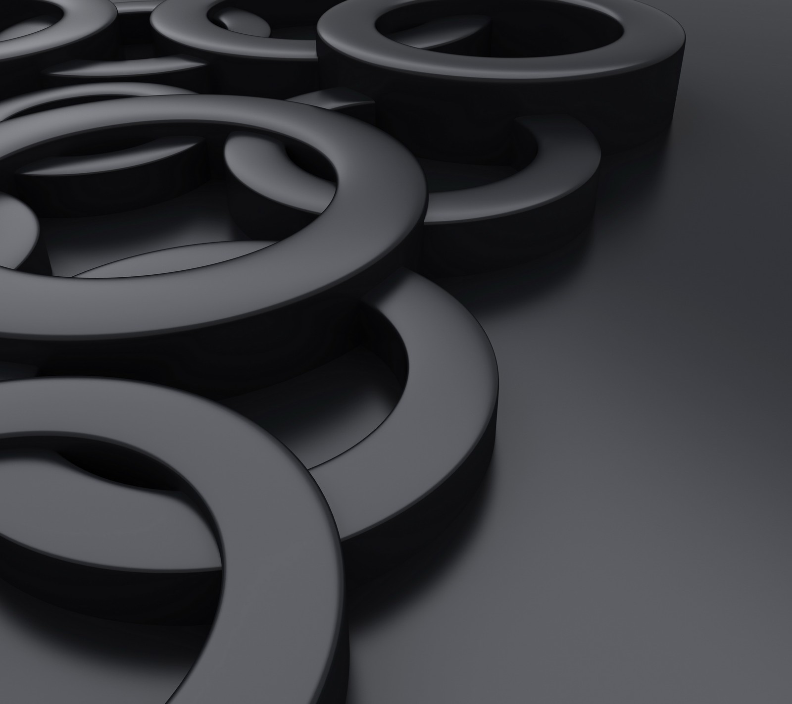 A close up of a bunch of black rings on a table (abstract, black metallic, design background)