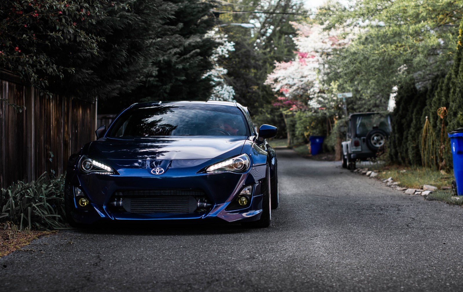 Un primer plano de un coche azul estacionado en la calle (coche, toyota)