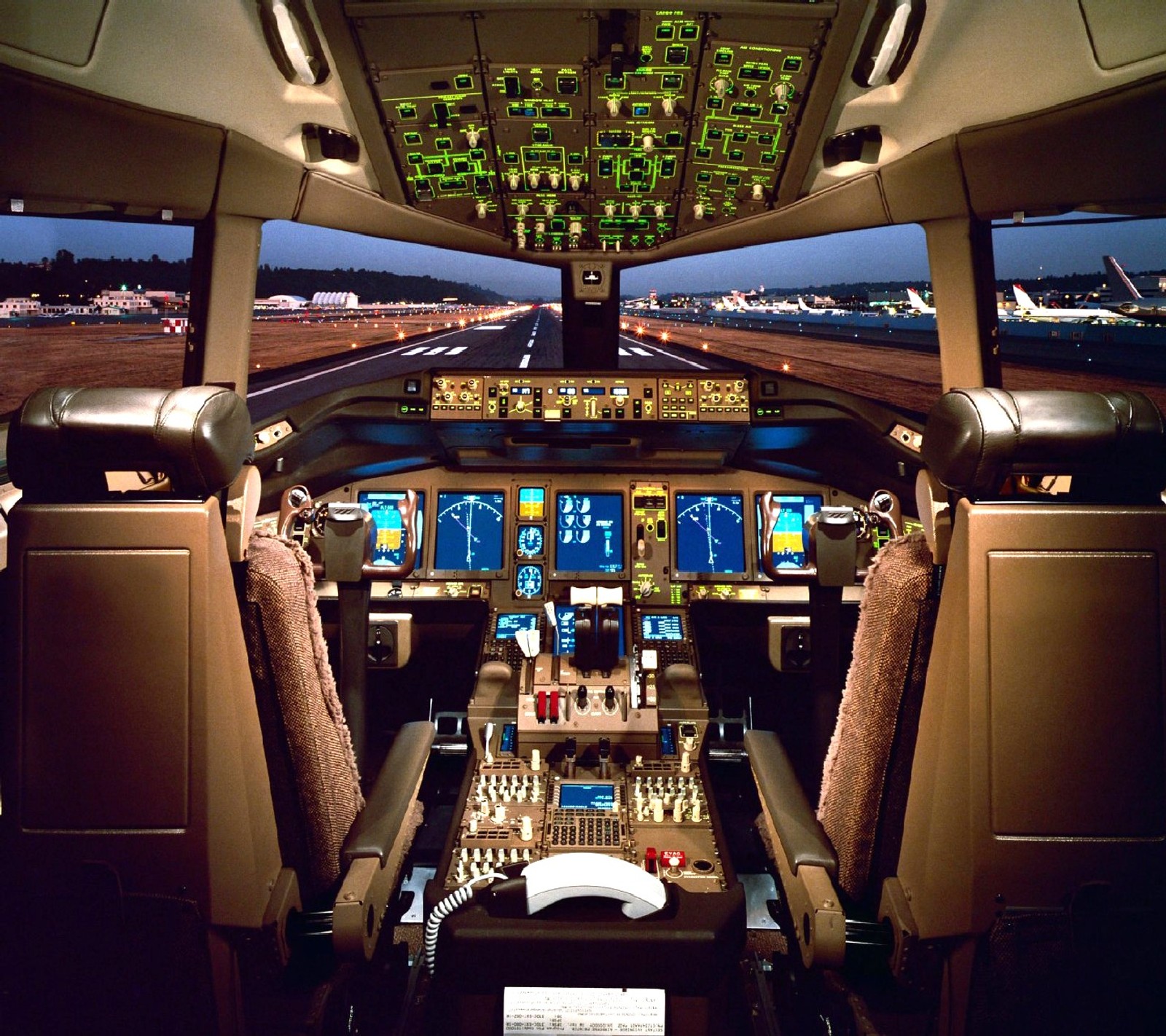 Um close de um cockpit com várias telas e um painel de controle (boeing 777)