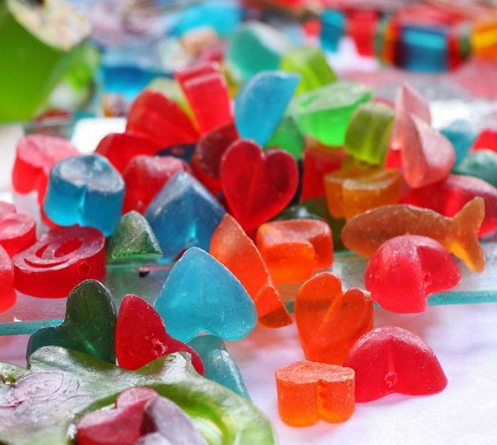 There are many different colored gummy bears on a table (colors, cute, hearts)