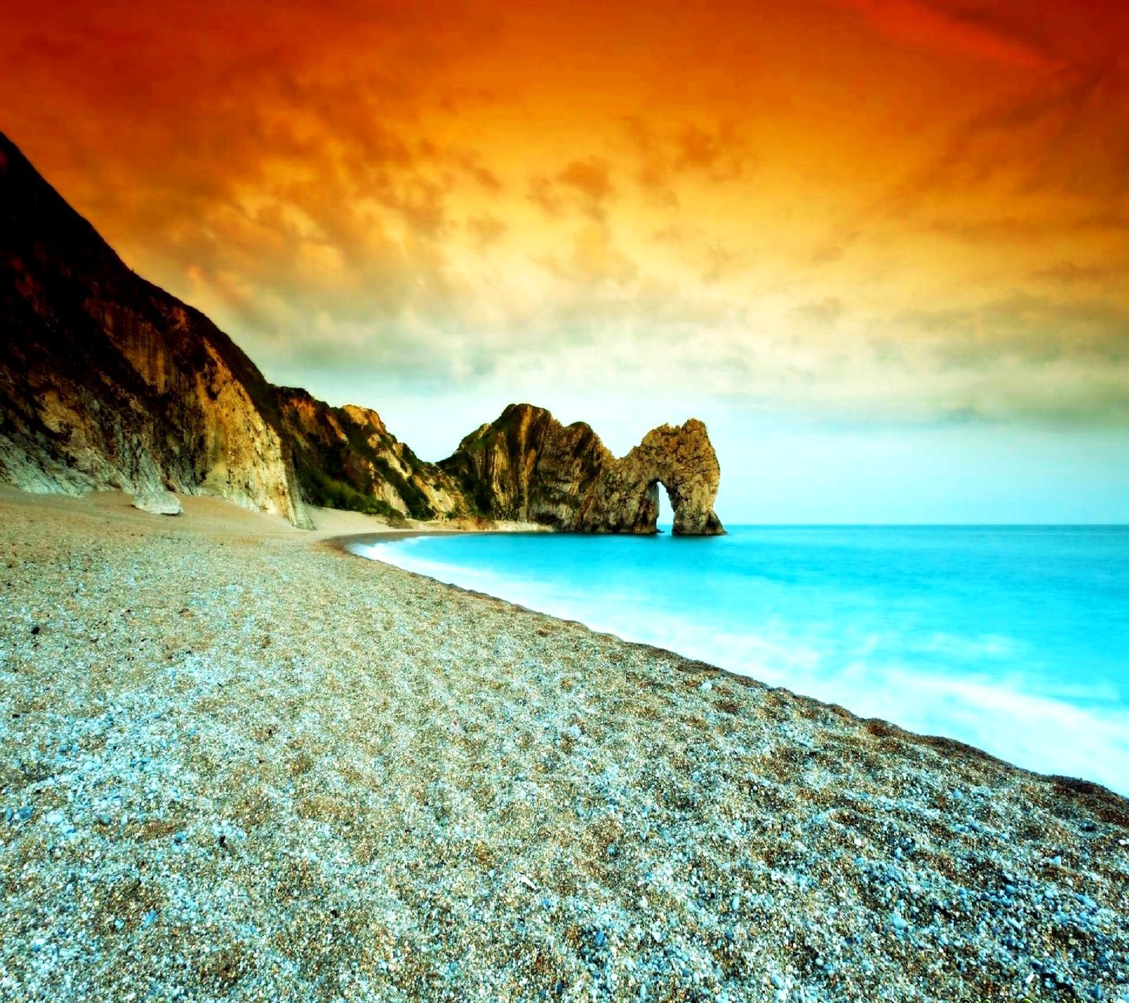 Arafed view of a beach with a rocky cliff and a body of water (nature)