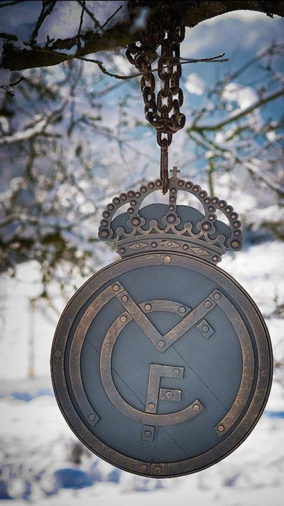 Logo del Real Madrid colgando de una rama en la naturaleza