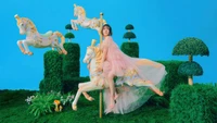 Wendy de Red Velvet dans un cadre fantaisiste, chevauchant un cheval de carrousel au milieu d'une verdure vibrante, incarnant le thème enchanteur "Ressens mon rythme".