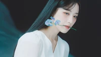 Shuhua with a delicate flower, embodying elegance and serenity.