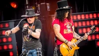 Axl Rose et Slash se produisent énergiquement sur scène lors de la "Not in This Lifetime Tour", mettant en avant leur présence rock emblématique et leur talent musical.