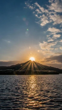 Atardecer sobre un lago tranquilo con silueta de montaña